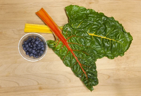 Blueberries and chard. — Stock Photo, Image