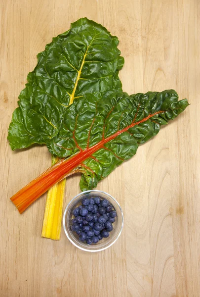 Chard and dish of blueberries. — Stock Photo, Image