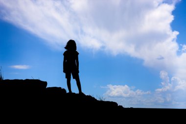 siluet kız tepede duruyor.