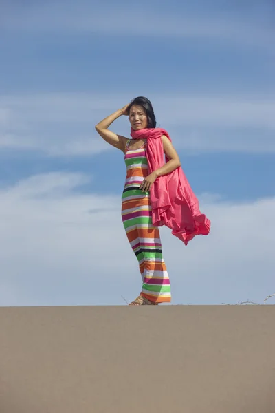 Mulher envolta em pano rosa na areia — Fotografia de Stock