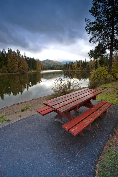 Picknickbord nära sjön. — Stockfoto