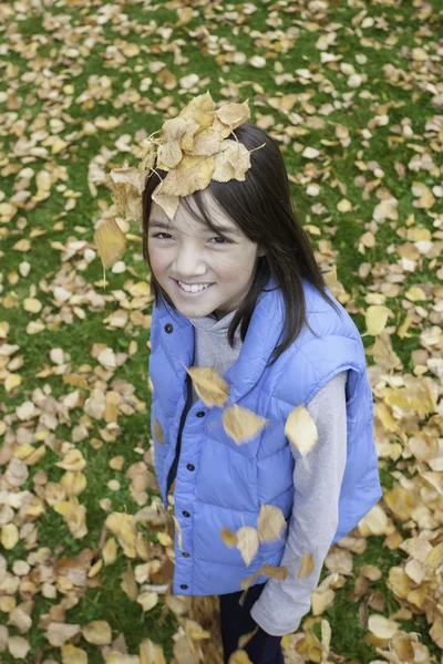 女の子は彼女の頭の上の葉を持っています. — ストック写真