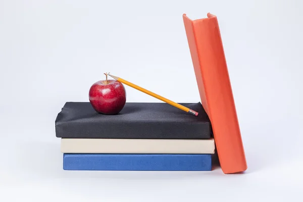 Lápis se inclina na maçã em livros . — Fotografia de Stock