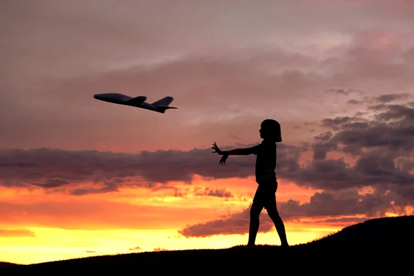 女の子は、おもちゃの飛行機が飛ぶ. — ストック写真