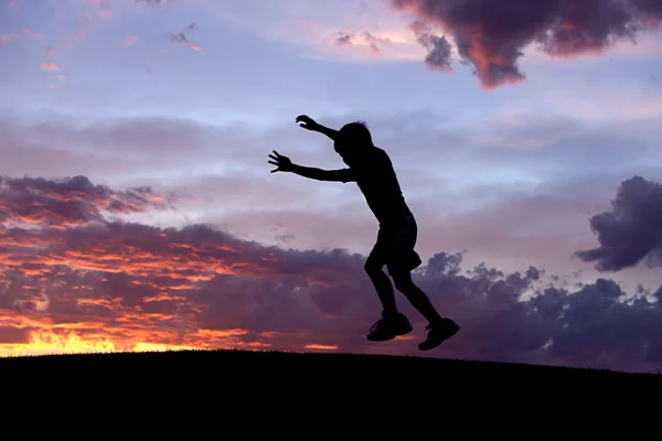 Boy jumps at sunset. Royalty Free Stock Photos