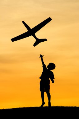 Boy launches toy plane. clipart