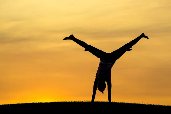 Middle of a cartwheel at sunset. — Stock Photo, Image