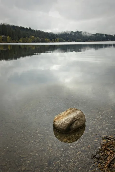 Uma Pequena Pedra Está Água Calma Lago Hauser Sob Céu — Fotografia de Stock
