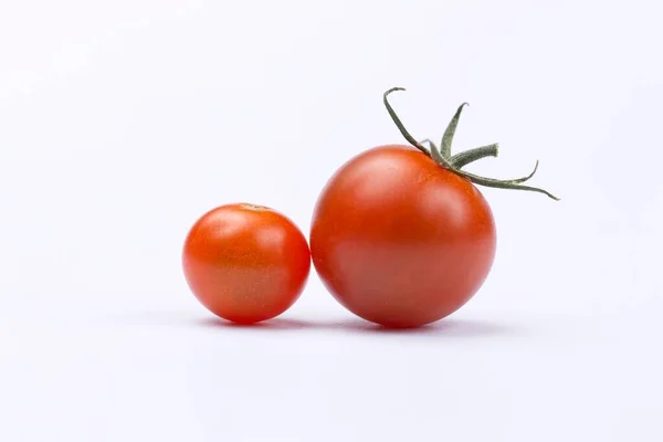 一个大的和一个小的樱桃西红柿设置在一个工作室设置的白色背景 — 图库照片