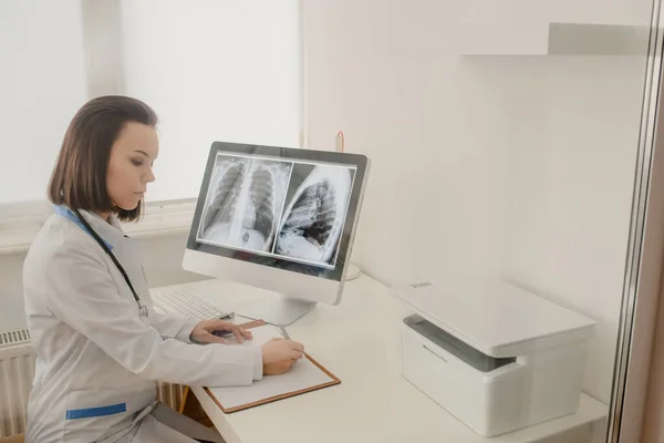 Genç kadın radyoloji doktoru röntgen ve bilgisayar tomografisi analizi ve not defterine tıbbi tanımlama.
