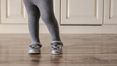 Küçük kız ortopedik ayakkabıları ahşap zemine kapatın. Metin için boşluk