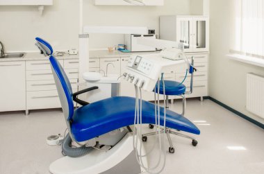 Boş stomatoloji kliniği, dişçi koltuğu ve gerekli tüm ekipmanlar.
