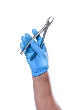 Diş hekimi eli beyaz arka planda diş pensesi tutuyor.. 