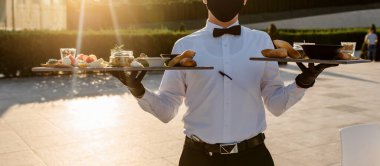 Restoranda garsonun elinde aperatifle birlikte tabakları kapat.. 