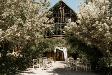 Düğün seremonisi. Sandalyeler ve çiçeklerden düğün kemeri.. 