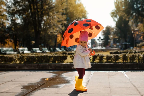 Счастливая Улыбчивая Двухлетняя Девочка Желтых Дождевых Сапогах Играет Красной Пуговицей — стоковое фото