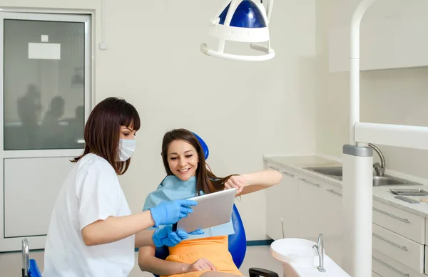 Młoda Dentystka Pokazuje Swojemu Pacjentowi Cyfrowe Prześwietlenie Stomatologiczne Tablecie Klinice — Zdjęcie stockowe