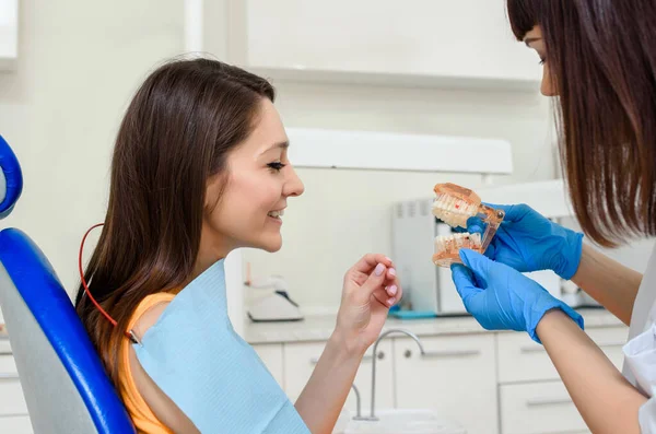 Zbliżenie Młodej Kobiety Dentysta Wyjaśnić Pacjentowi Modelu Szczękowym Zęba Pozycję — Zdjęcie stockowe