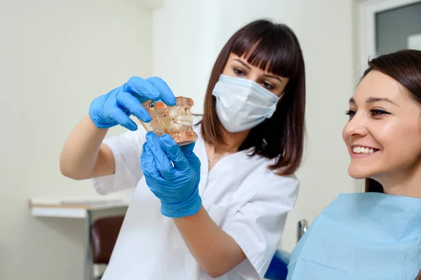 Zbliżenie Młodej Kobiety Dentysta Wyjaśnić Pacjentowi Modelu Szczękowym Zęba Pozycję — Zdjęcie stockowe