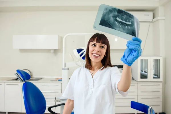 Genç Mutlu Bir Dişçi Elinde Diş Röntgeni Panoramik Radyografisi Tutuyor — Stok fotoğraf