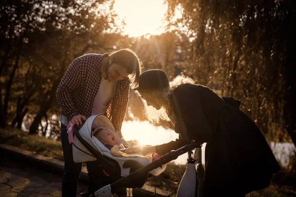 Młoda Szczęśliwa Rodzina Spaceruje Swoim Dzieckiem Wózku Jesiennym Parku Śmieją — Zdjęcie stockowe