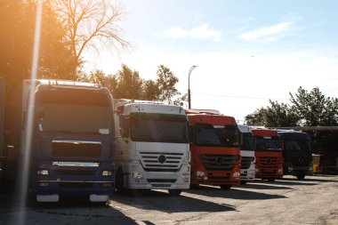 Kamyon parkında gün batımında kalan kamyonların ön görüntüsü. Nakliye konsepti. Lojistik şirketi