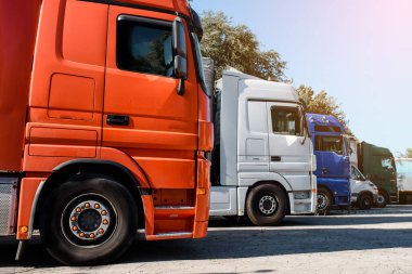 Gün batımında kamyonun park yerinde kalan kamyonların yan görüntüsü. Nakliye konsepti. Lojistik şirketi