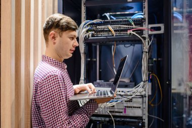 Sunucu odasında bir teknisyen / Bu dizüstü bilgisayar mühendisi / tutun ve sunucu hatasını bağlayan veya düzelten interneti ayarlayın.