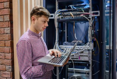 Sunucu odasında bir teknisyen / Bu dizüstü bilgisayar mühendisi / tutun ve sunucu hatasını bağlayan veya düzelten interneti ayarlayın.