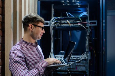 Sunucu odasında bir teknisyen / Gözlüklü bir mühendis / mühendis defteri tutun ve sunucu hatasını bağlayan veya düzelten interneti ayarlayın.