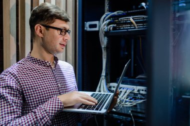 Sunucu odasında bir teknisyen / Gözlüklü bir mühendis / mühendis defteri tutun ve sunucu hatasını bağlayan veya düzelten interneti ayarlayın.