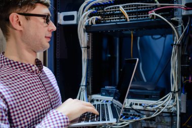 Sunucu odasında bir teknisyen / Gözlüklü bir mühendis / mühendis defteri tutun ve sunucu hatasını bağlayan veya düzelten interneti ayarlayın.