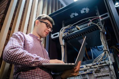 Sunucu odasında bir teknisyen / Gözlüklü bir mühendis / mühendis defteri tutun ve sunucu hatasını bağlayan veya düzelten interneti ayarlayın.