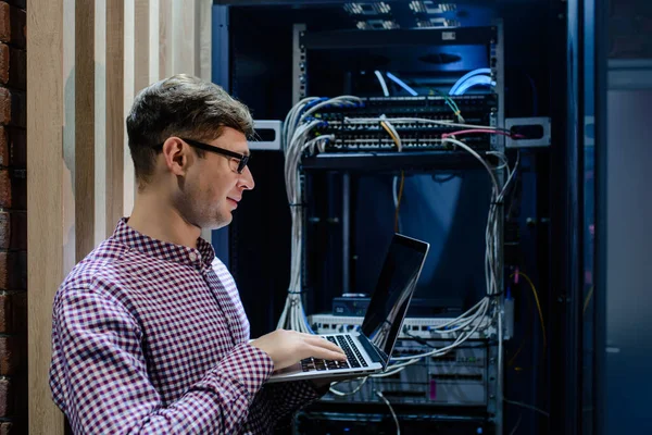 Sunucu odasında bir teknisyen / Gözlüklü bir mühendis / mühendis defteri tutun ve sunucu hatasını bağlayan veya düzelten interneti ayarlayın.