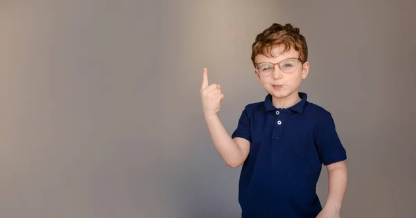 Happy Little Boy Kid Blue Shirt Glasses Gray Background Pointing — Stock Fotó
