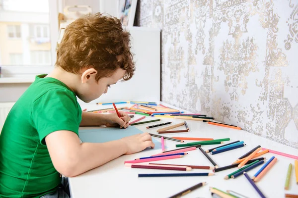 Vista Lateral Niño Que Está Pintando Sobre Papel Azul Mesa —  Fotos de Stock