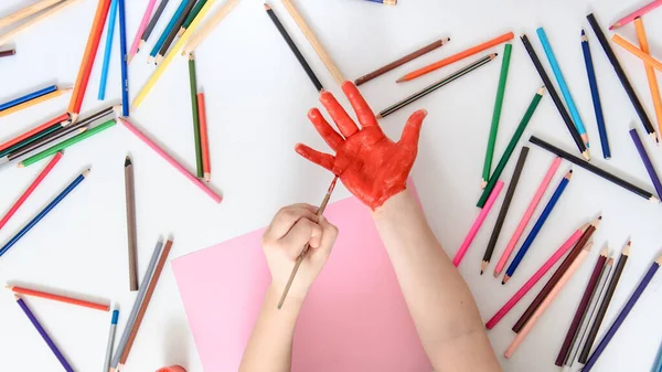 Vista Superior Niño Que Está Pintando Mano Con Pintura Roja — Foto de Stock