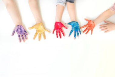 Sarı, mavi, mor ve turuncu renklerle boyanmış beyaz arkaplan boyalı çocukların ellerini kapat. Metin kopyalama alanı için boş alan