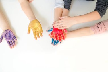 Sarı, mavi, mor ve turuncu renklerle boyanmış beyaz arkaplan boyalı çocukların ellerini kapat. Metin kopyalama alanı için boş alan