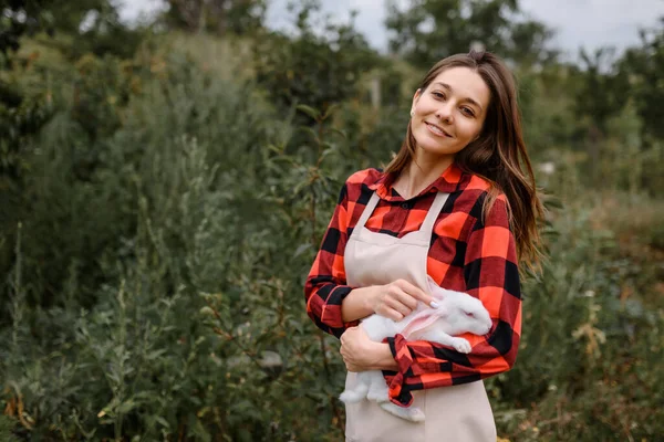 Mladá Šťastná Usměvavá Farmářka Dívá Kamery Drží Venku Bílého Králíka — Stock fotografie