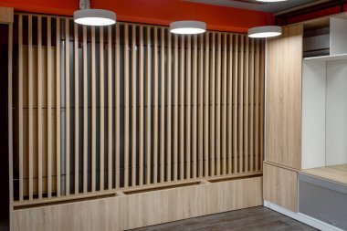 Tahtalardan ahşap duvarları ve tavan lambaları olan modern bir ofis.