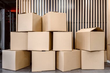 Bir ofiste gönderilmeye hazır bir sürü karton kutu var.