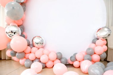 Mesajınız için pembe ve gri balonlardan beyaz fotokopi alanına kadar fotoğraf bölgesini kapatın. Parti balonlarla süslenmiş.