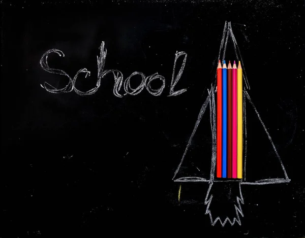 学校のコンセプトに戻って それに単語の学校と黒板に色の鉛筆からロケットを描きます テキストのスペースをコピー — ストック写真