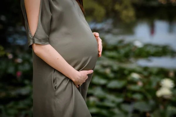 Großaufnahme Hält Eine Schwangere Frau Einem Grünen Kleid Ihren Bauch — Stockfoto