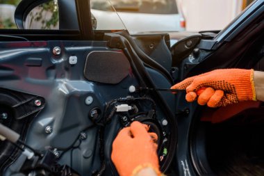 Tamirci elleri arabanın kapısının içini onarıyor. Araba kapısının restorasyonu. Yenileme süreci