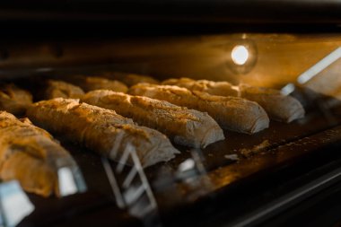 Bir fırın imalatında ekmek ekmeği pişirme işlemini kapat. Elektrikli fırında gagalı ekmek.