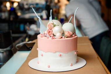 Güzel pastayı beyaz küreler ve pembe güllerle kapat.