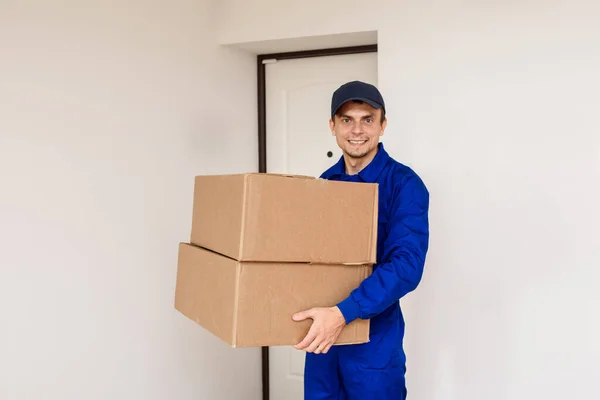 Junger Glücklich Lächelnder Mann Blauem Overall Bringt Ein Paket Zwei — Stockfoto
