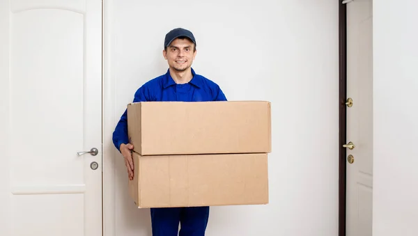 Junger Glücklich Lächelnder Mann Blauem Overall Bringt Ein Paket Zwei — Stockfoto